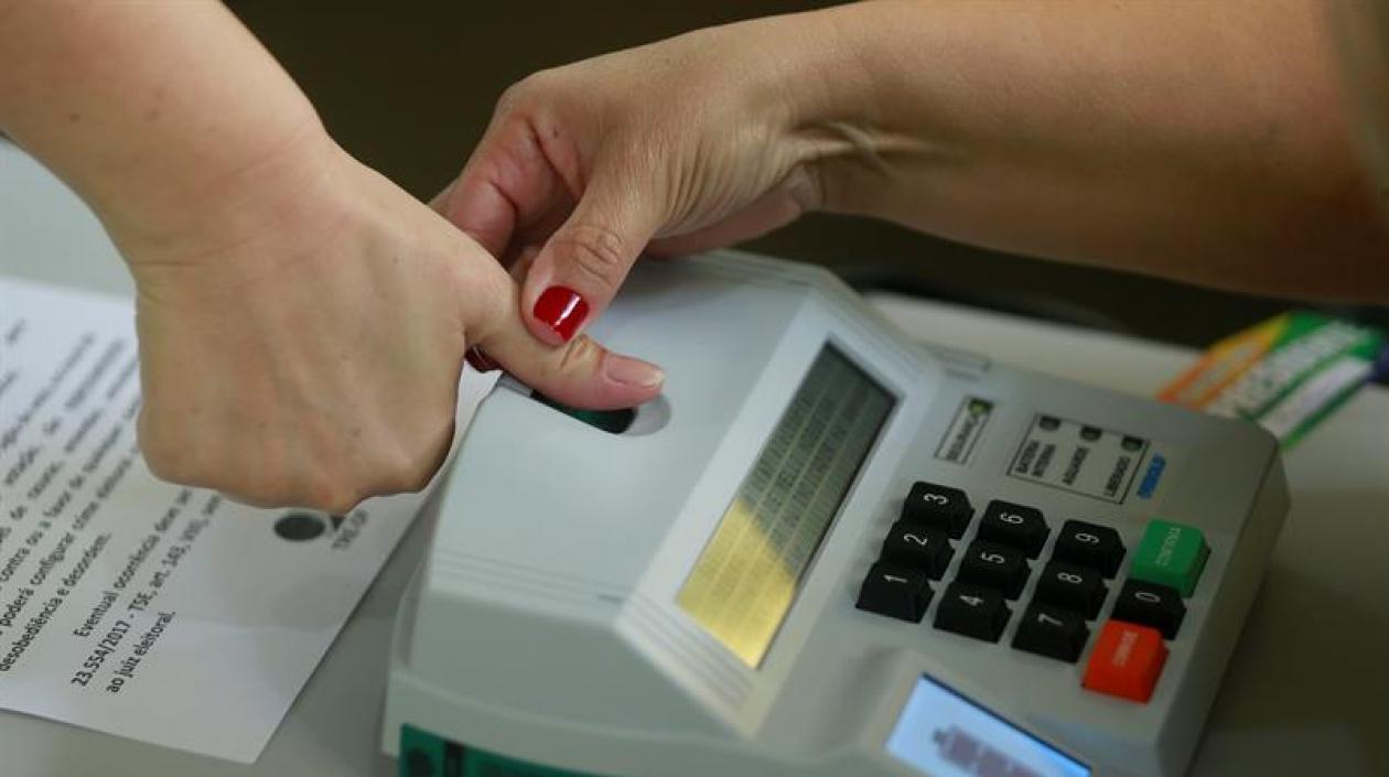 Una mujer registra su huella antes de votar hoy en la ciudad de Brasilia.