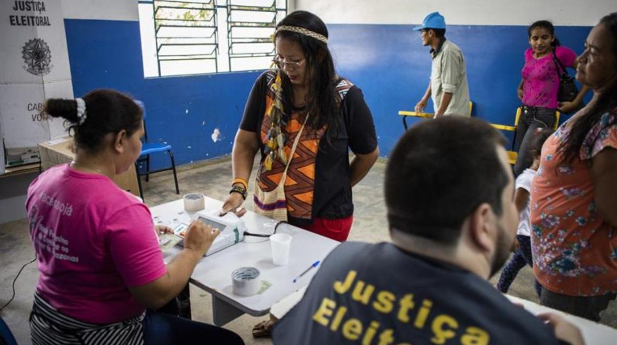  La indígena y pedagoga de la etnia Baré Ana Claudia Martins Tomas (2i), de 40 años, hace su identificación biométrica antes de votar en la comunidad rural de "Nossa Senhora do Livramento", en el Río Negro.