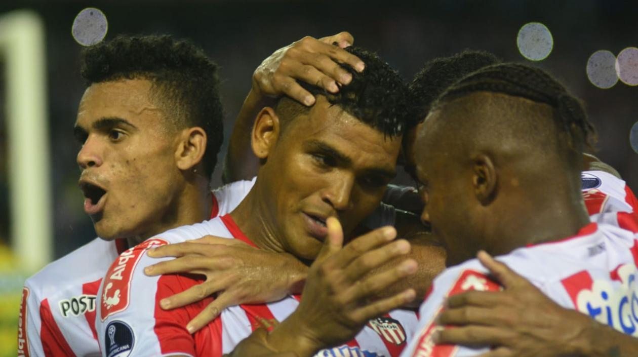 Jugadores de Junior celebran con Rafael Pérez tras su anotación.