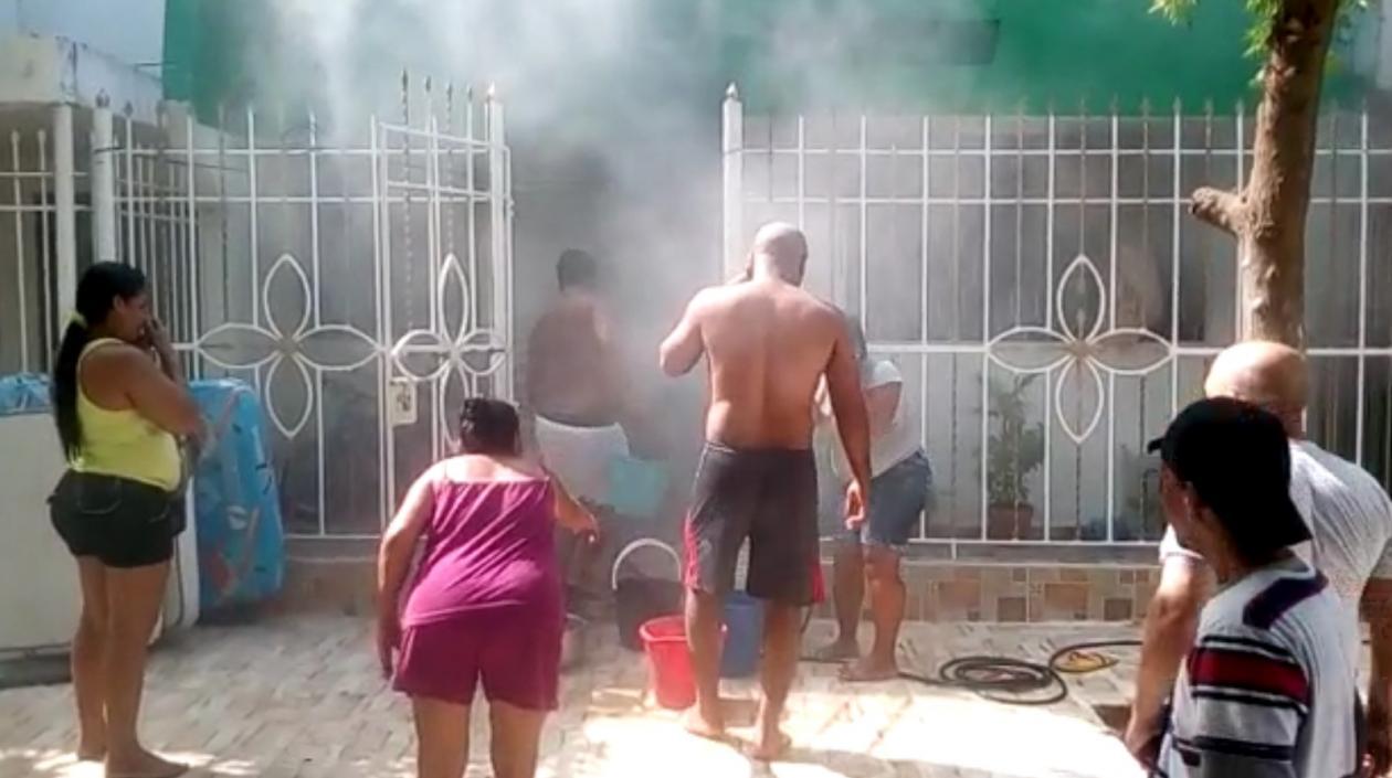 Residentes y vecinos sofocando las llamas con baldes con agua.