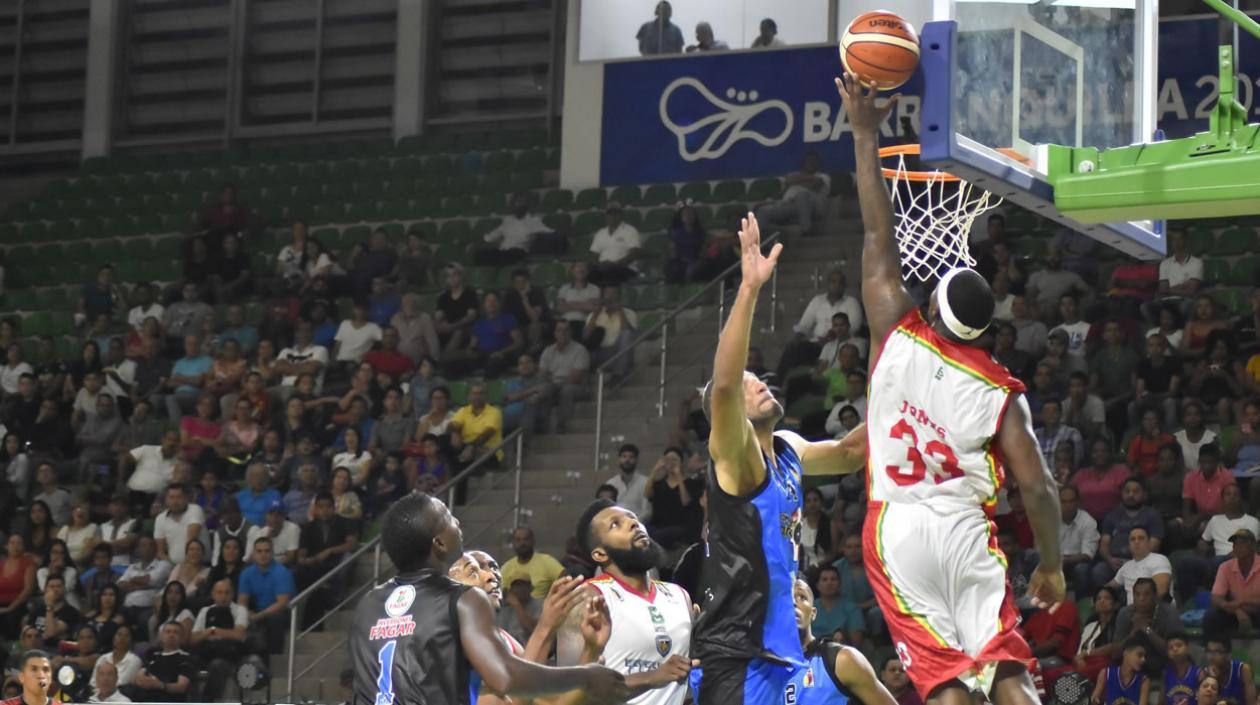 Troy Jones anota bajo la mirada de Michael Sneed. 