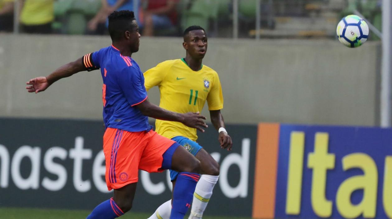 Vinicius Jr (d) de Brasil disputa un balón con Yeller Goez.