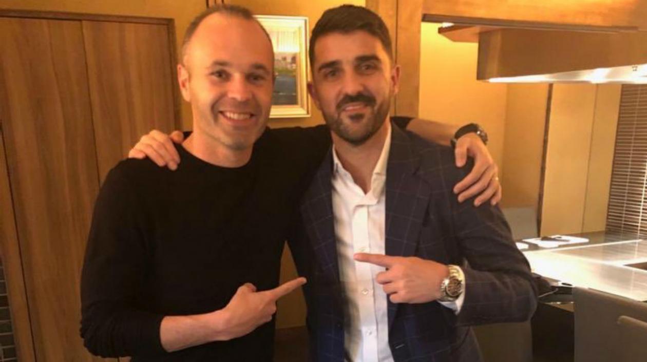 Andrés Iniesta recibiendo a David Villa. 