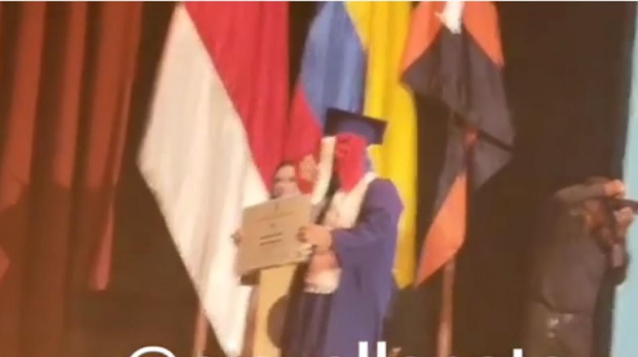 Momento en el que exhibe su diploma.