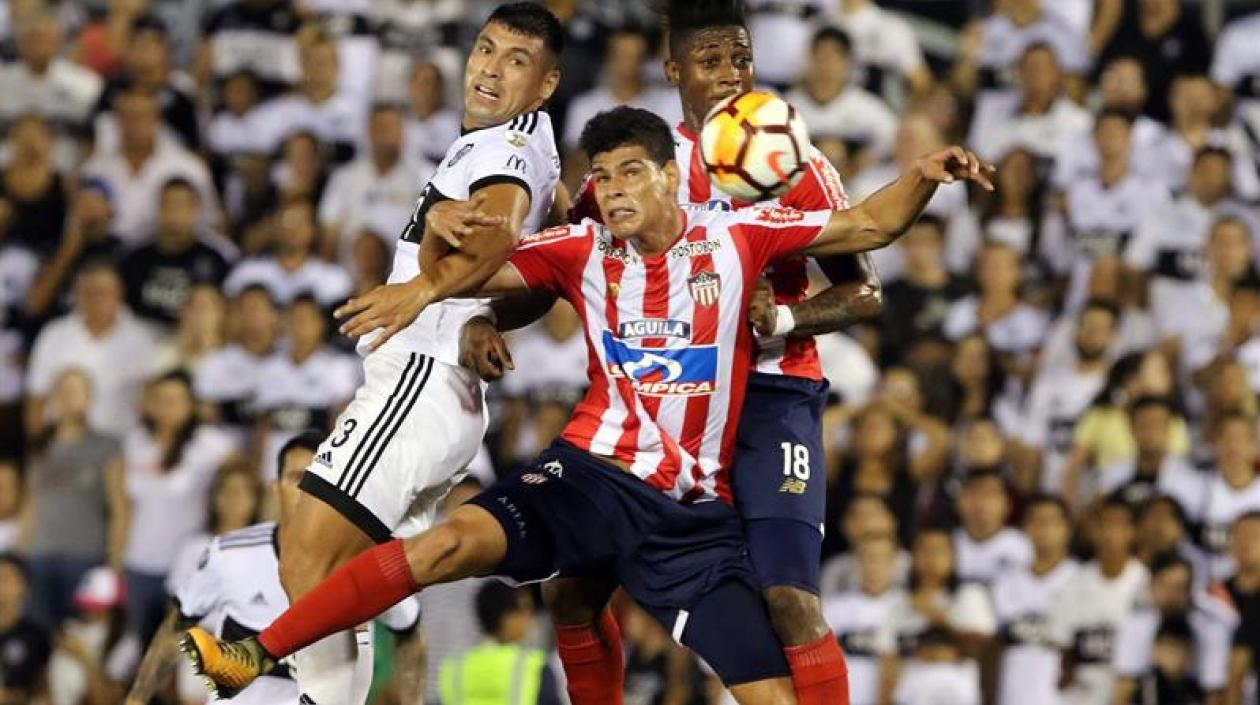 Jorge Arias y Yony González disputan el balón con Juan Patiño.