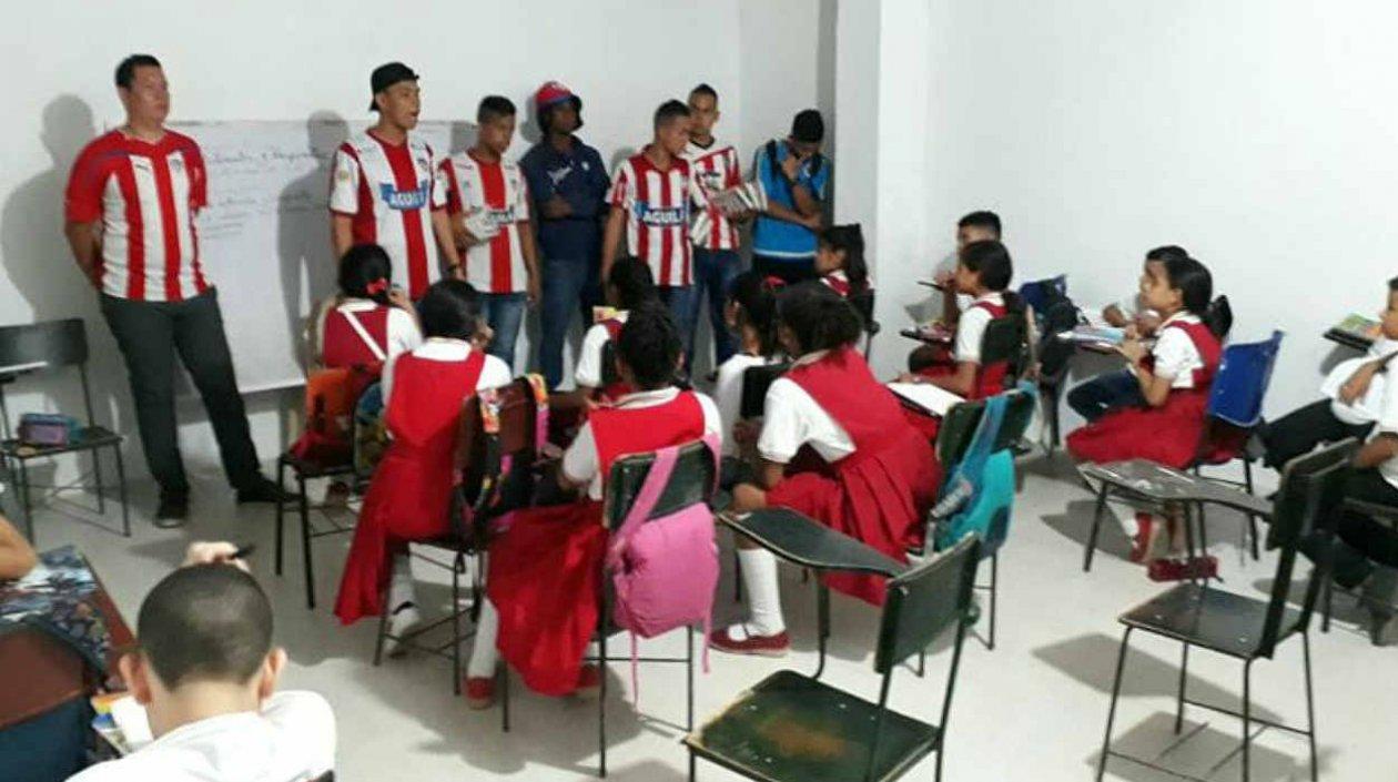 Hinchas llevando los útiles a los pequeños. 