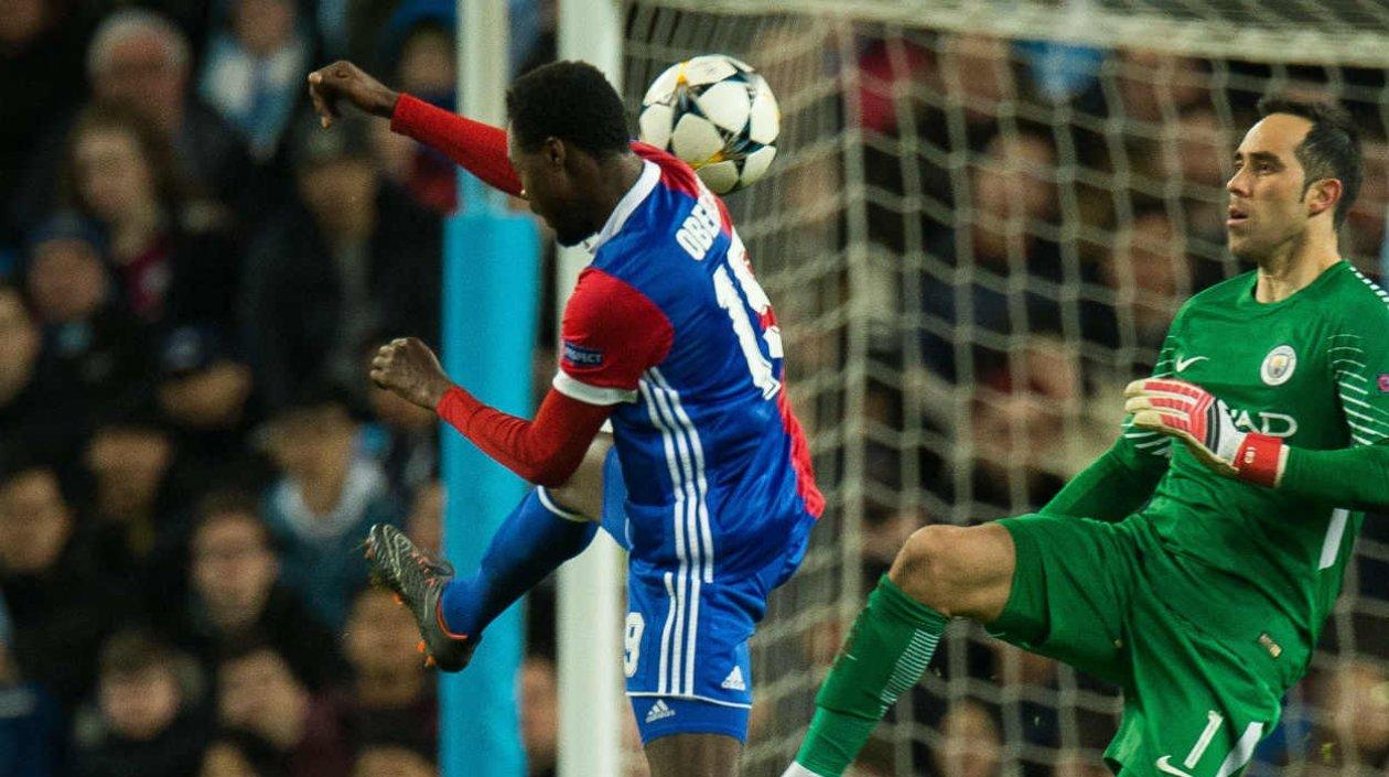 El arquero chileno Claudio Bravo (d) de Manchester disputa el balón con Dimitri Oberlin de Basilea.