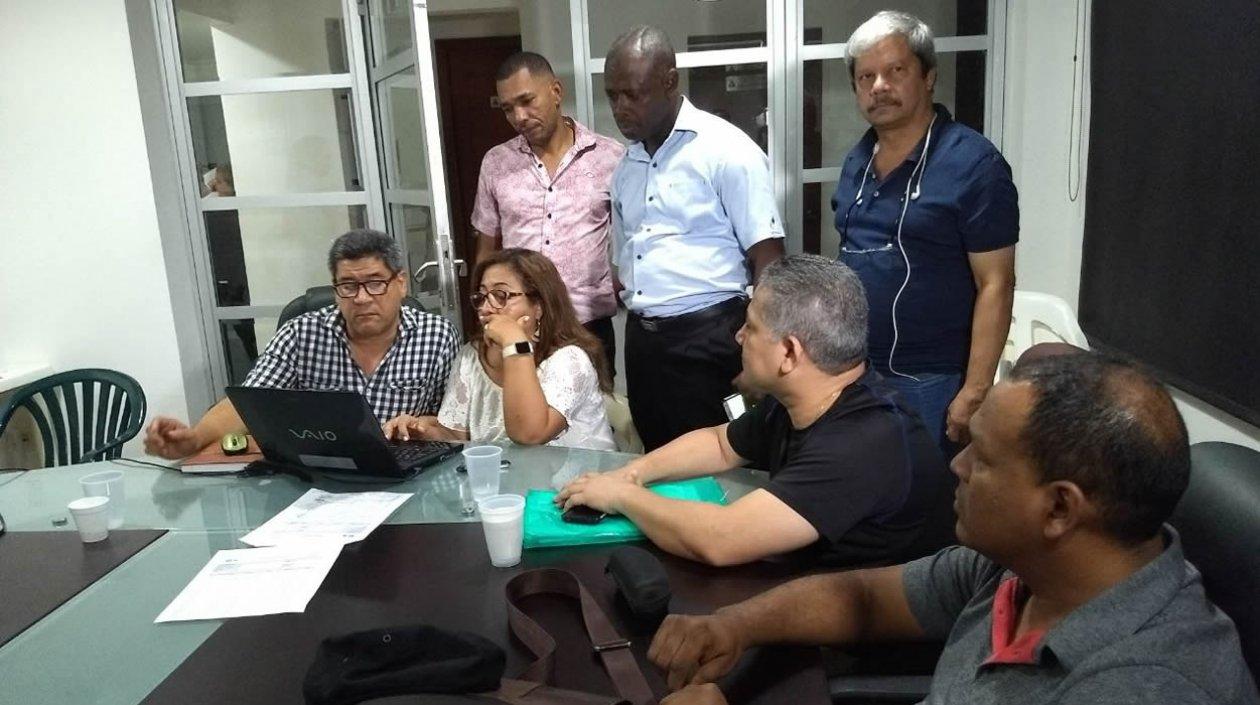 Trabajadores de la universidad firmando el acta.