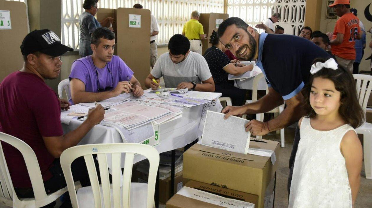 El senador Arturo Char deposita su voto, en compañía de su hija menor.