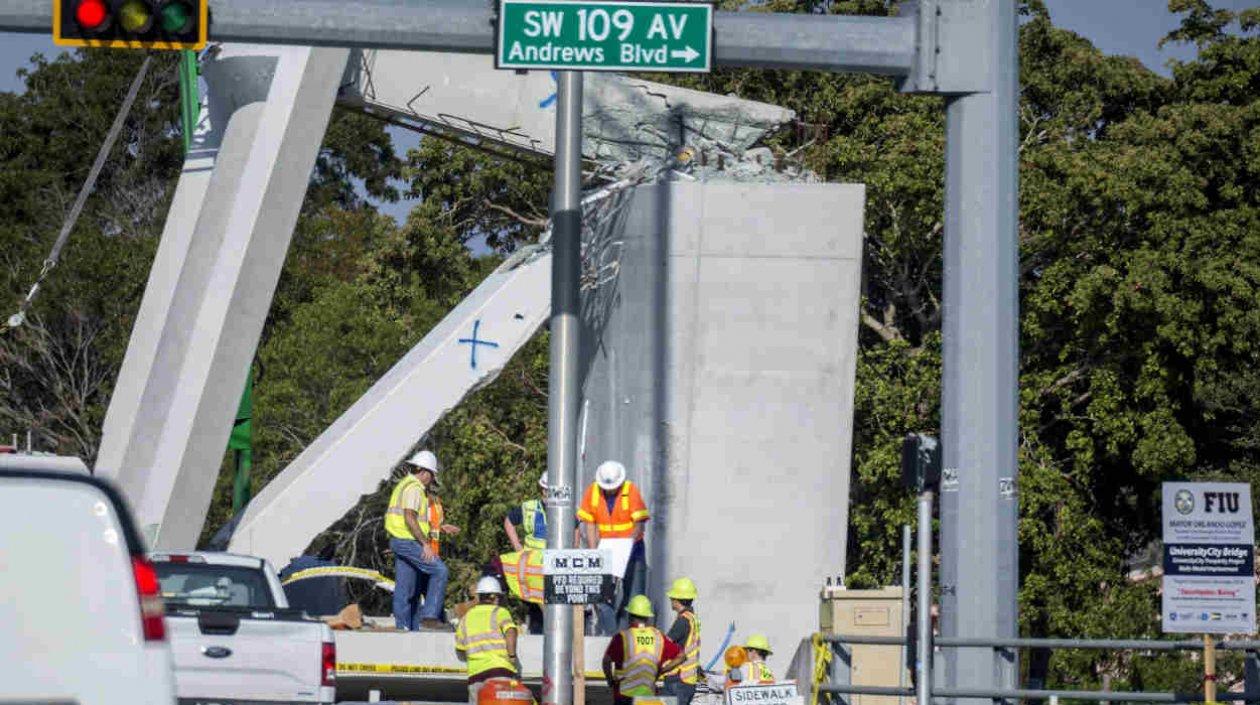 Obreros trabajando en la estructura caída del puente peatonal en Miami. 