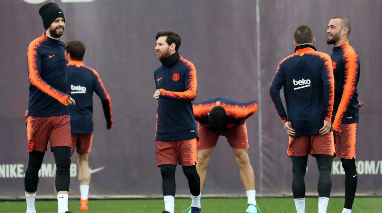 El delantero argentino del del FC Barcelona, Lionel Messi (c) y su compañero Gerard Pïqué (i) durante el entrenamiento que realiza la plantilla barcelonista para preparar el partido de liga que disputarán mañana ante el Sevilla FC.