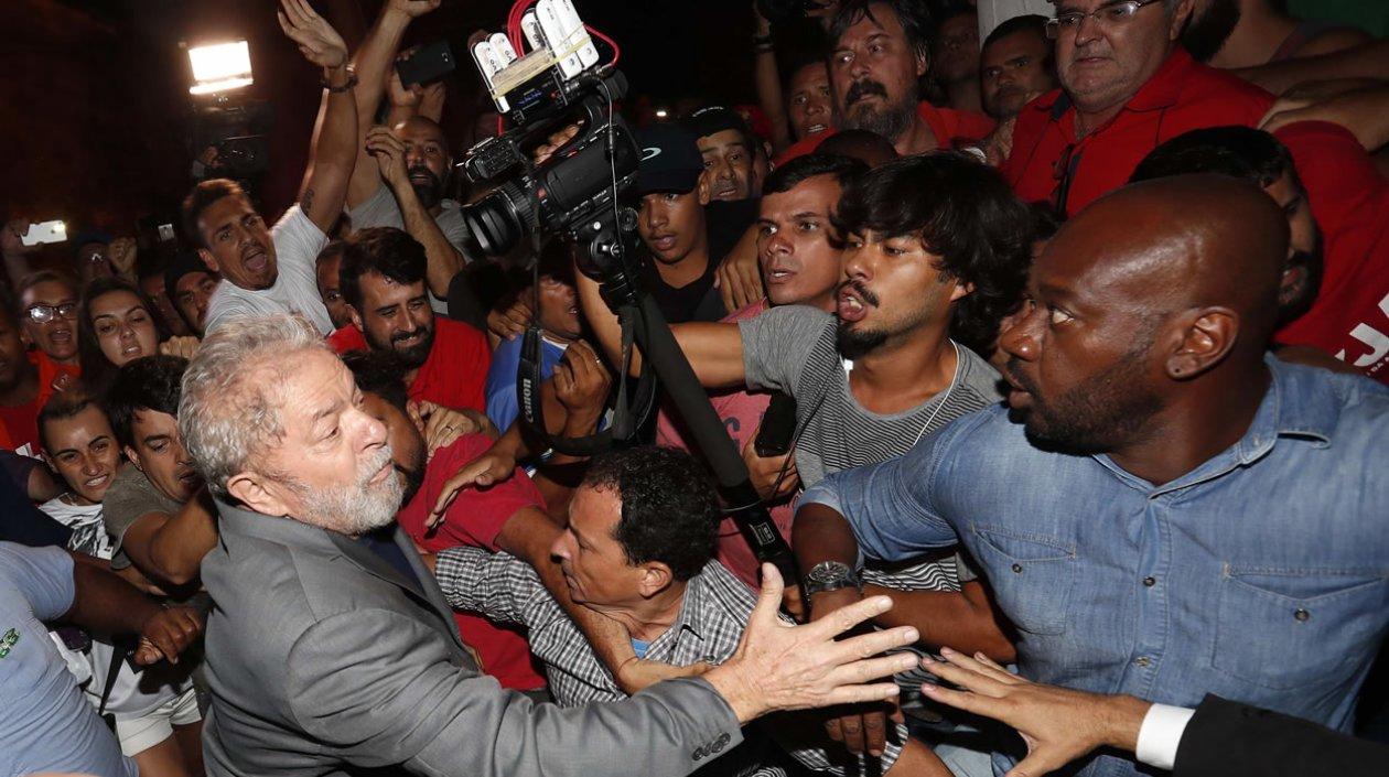 El expresidente brasileño Luiz Inácio Lula da Silva (i) abandona la sede del Sindicato de los Metalúrgicos de Sao Bernardo do Campo (Brasil) en medio de un tumulto para entregarse a las autoridades