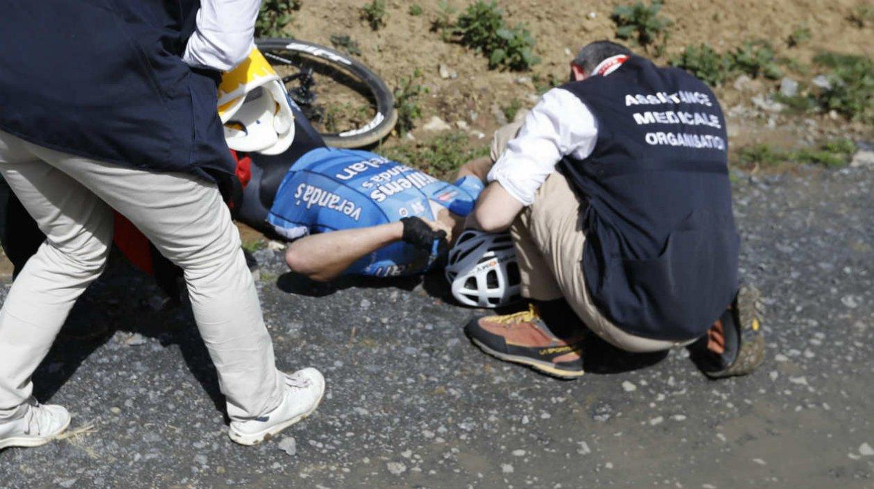 Michael Goolaerts desplomado al lado de su bicicleta. 