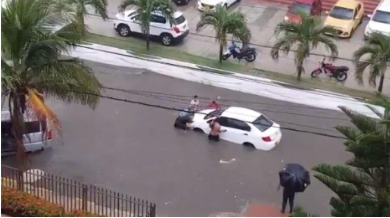 Momento en que ciudadanos ponen a salvo un vehículo parqueado en la carrera 50.