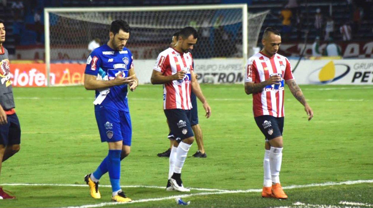 Jugadores de Junior saliendo con cara de vergüenza ante la afición en el Metropolitano.