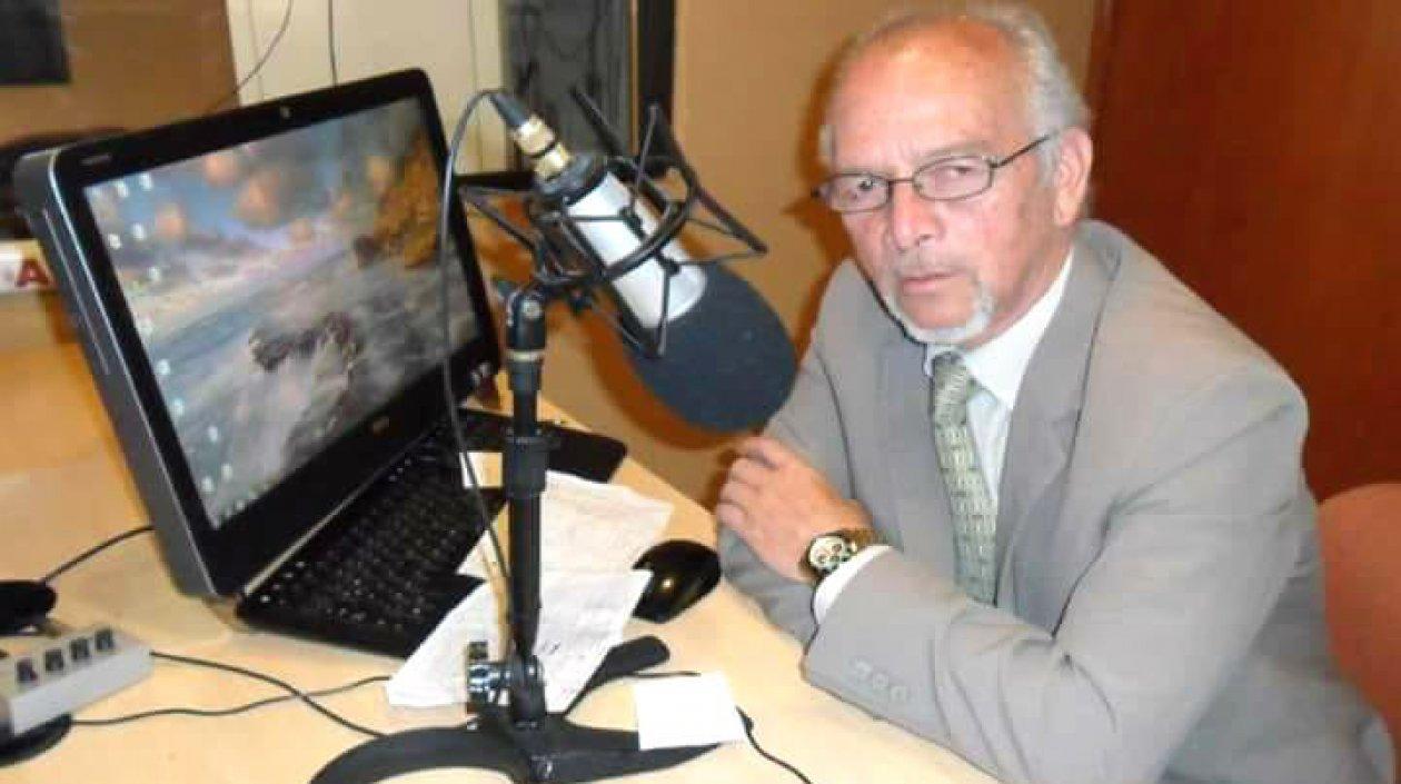 Alfredo Domínguez frente a dos valiosos elementos de trabajo: el micrófono y el computador.