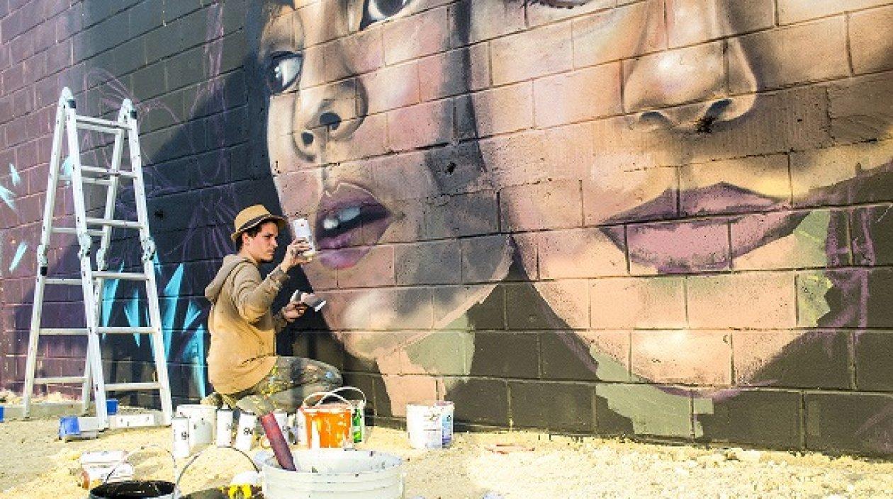 Artista creando mural para el evento de Killart.