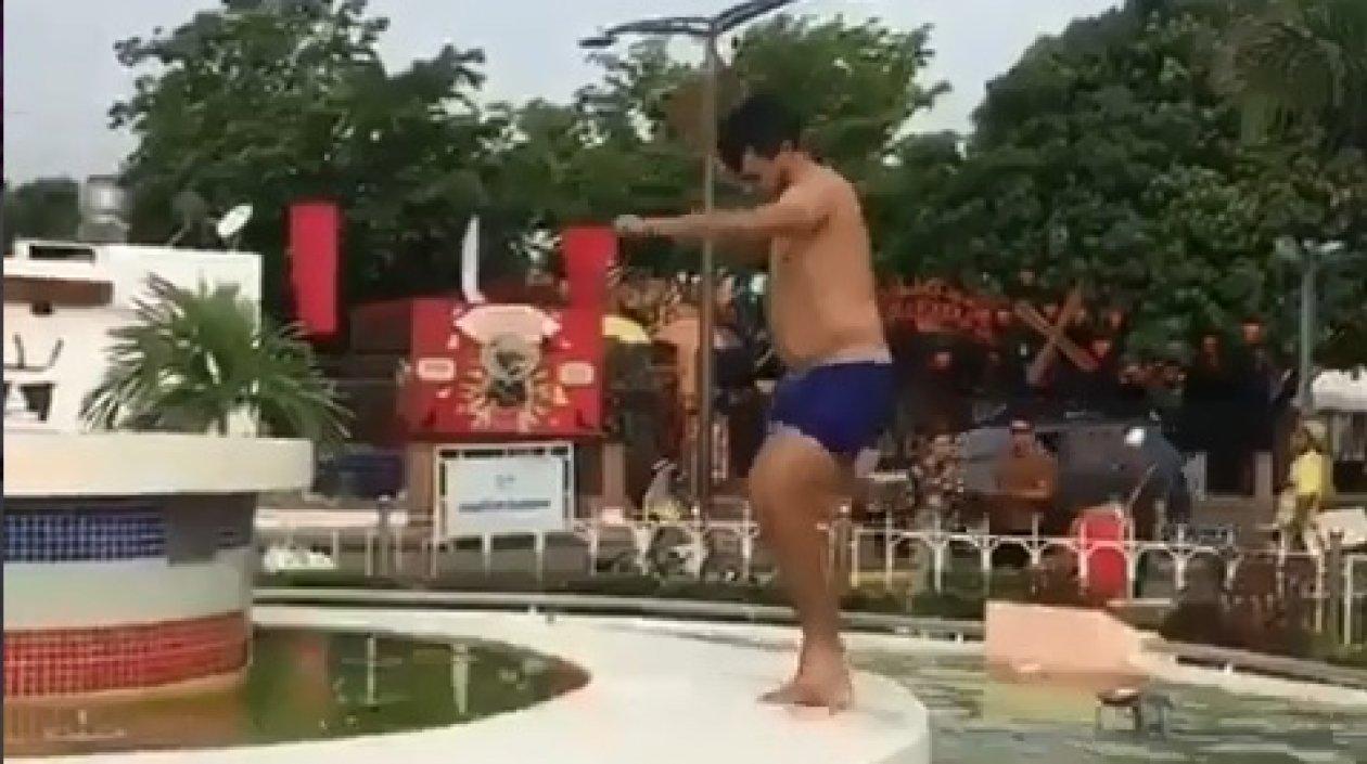 Hombre bañándose en una fuente.