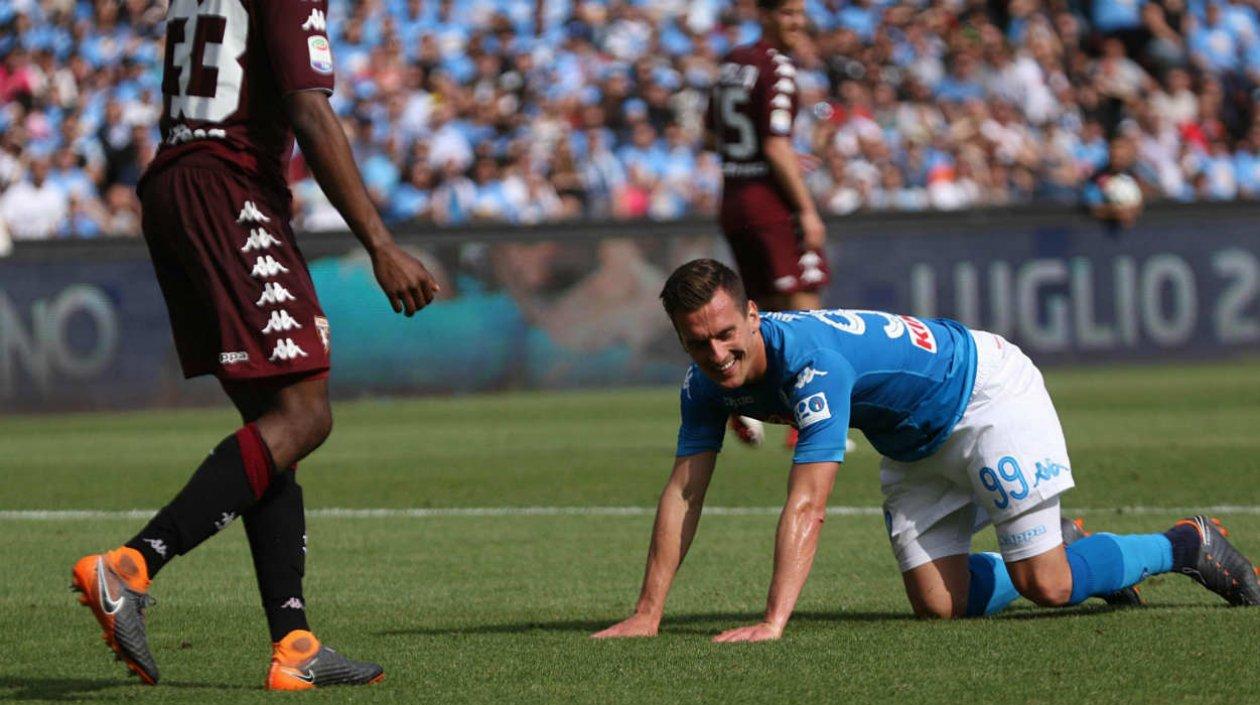  Arkadiusz Milik, del Nápoles, se lamenta en el piso tras una jugada. 