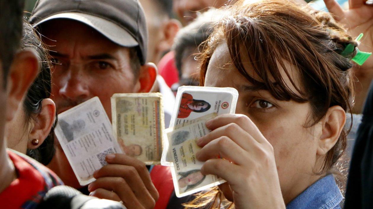 Una mujer venezolana muestra sus documentos.