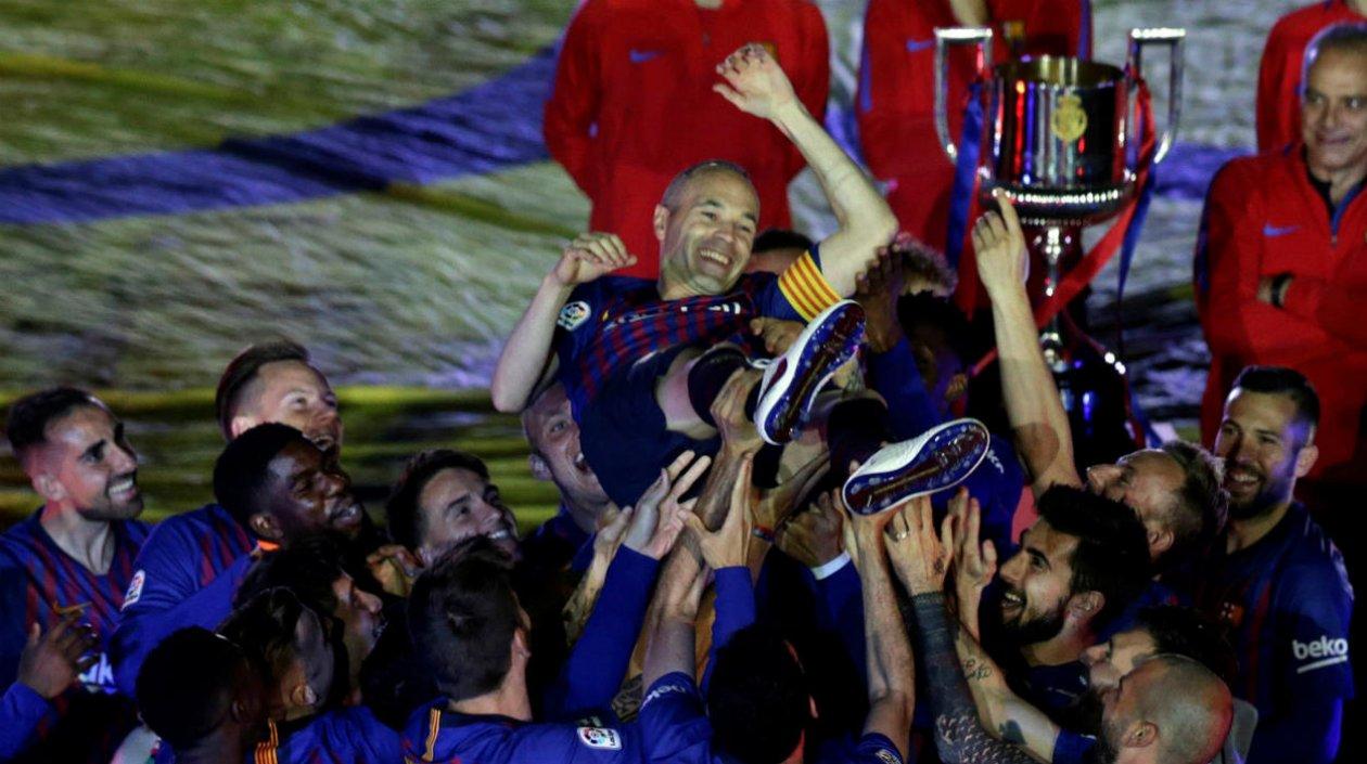 Andrés Iniesta es aupado por sus compañeros. 