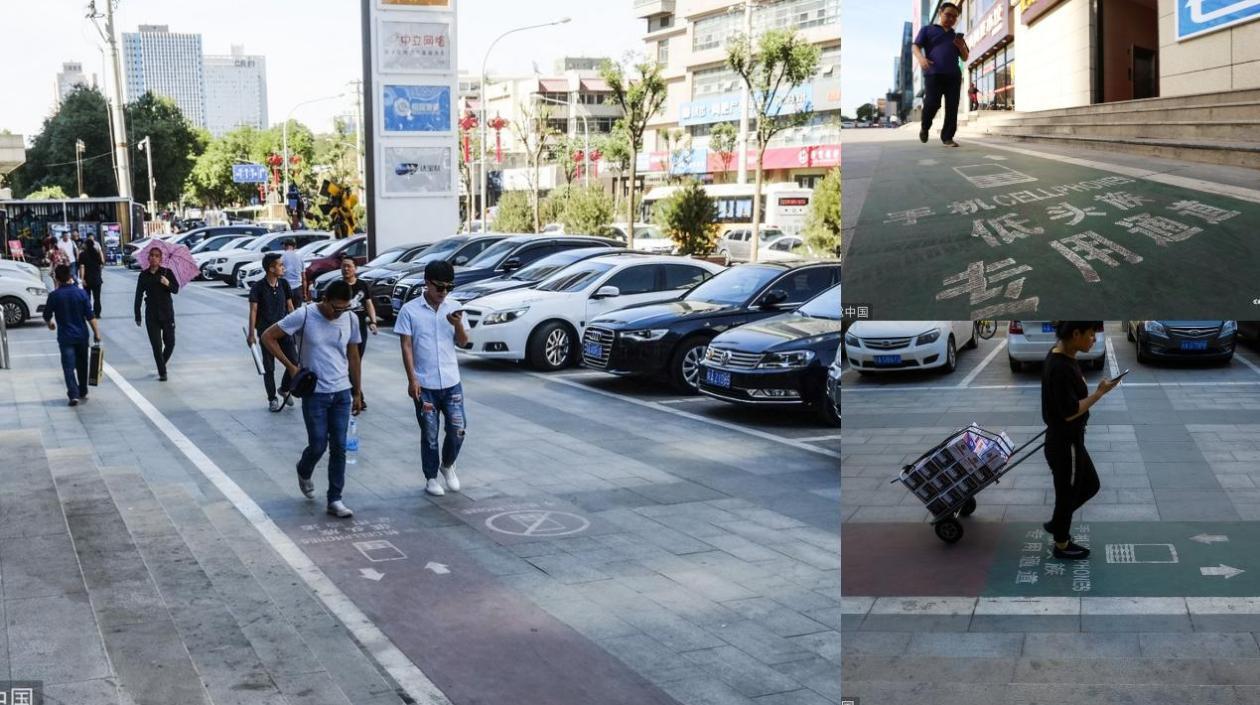 Muchas personas caminan mirando su celular por la calle.