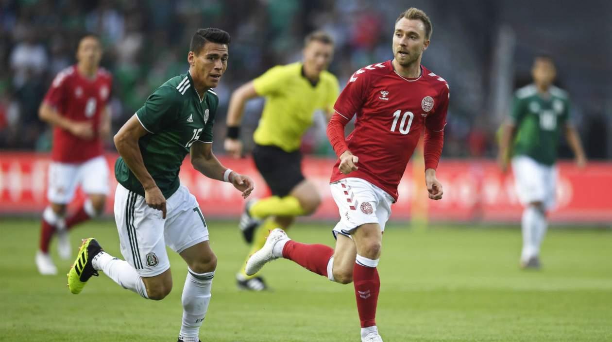 Héctor Moreno en acción de partido ante Christian Eriksen.