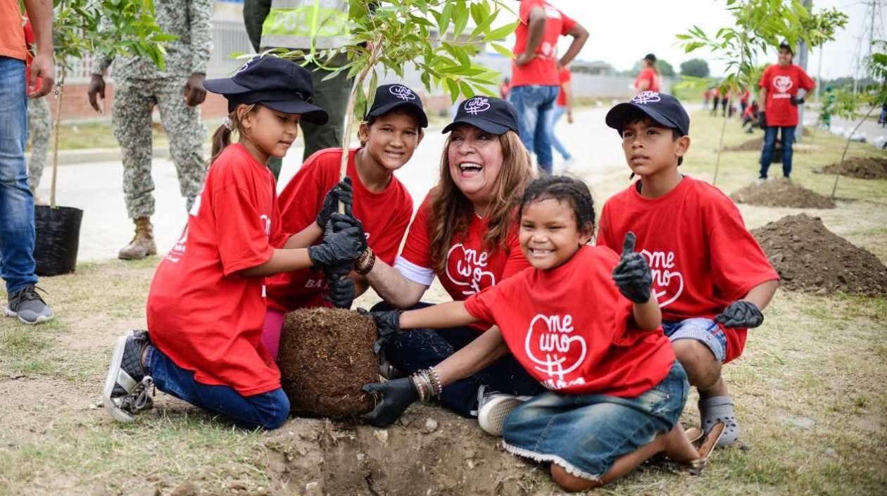 La primera dama de Soledad, Alba Olaya, con varios niños sembrando árboles.