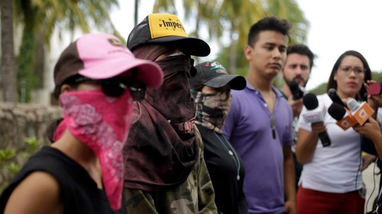 Voceros estudiantiles con el rostro cubierto.
