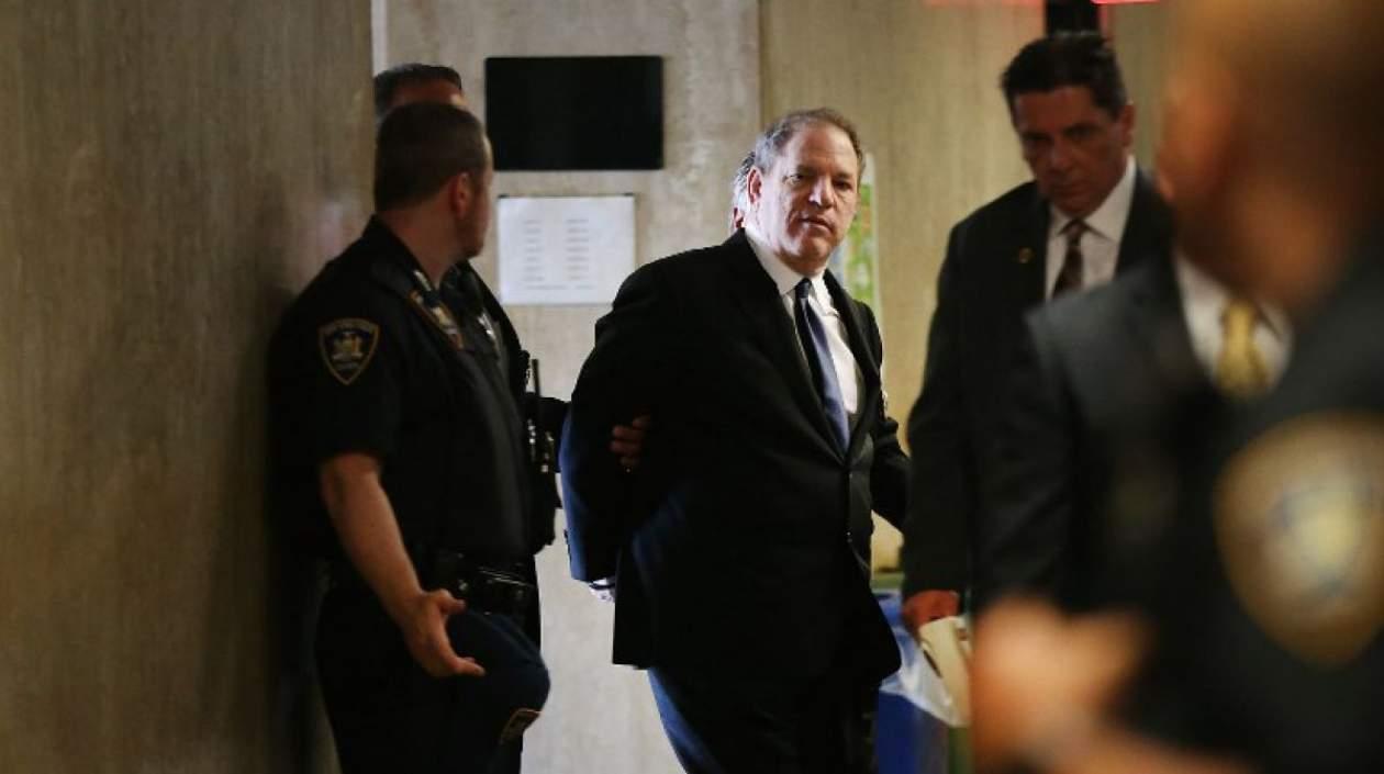 El productor de cine Harvey Weinstein escoltado por las autoridades.
