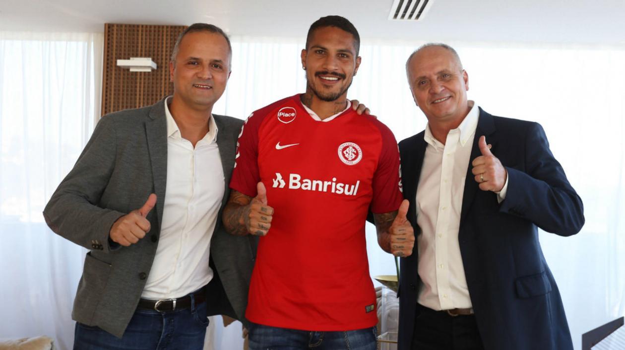 El futbolista peruano Paulo Guerrero (c) posando acompañado por el vicepresidente de fútbol del club Roberto Melo (i) y el presidente Marcelo Medeiros.