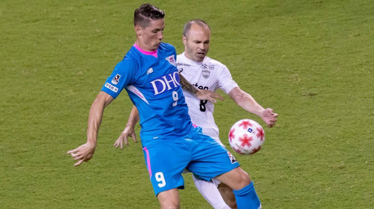 Fernando Torres disputa la pelota con Andrés Iniesta. 