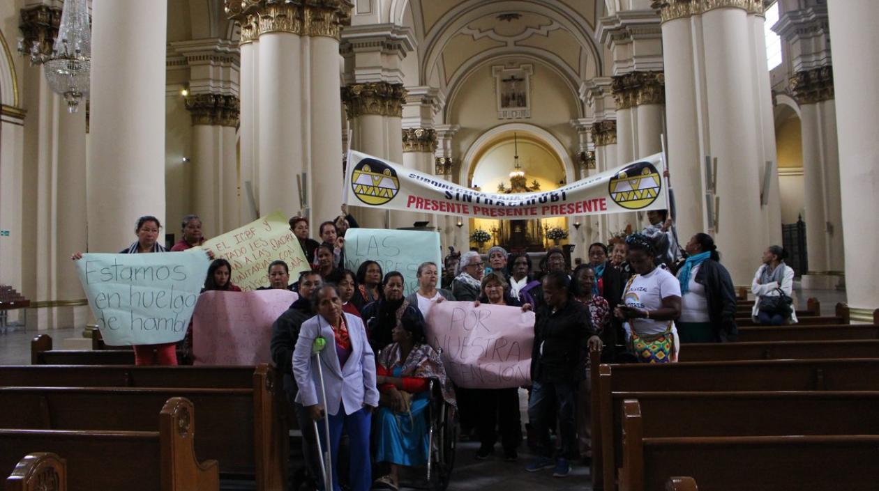 Madres comunitarias protestan en la catedral primada de Colombia por el fallo de la Corte Constitucional.