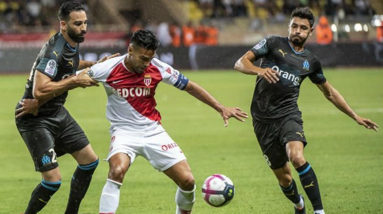 Falcao disputa la pelota con dos defensores. 