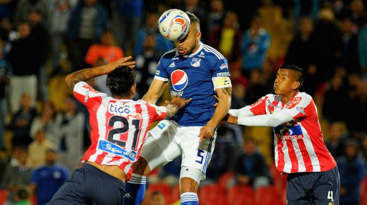 Jefferson Gómez y David Murillo disputando el balón con Andrés Cadavid.