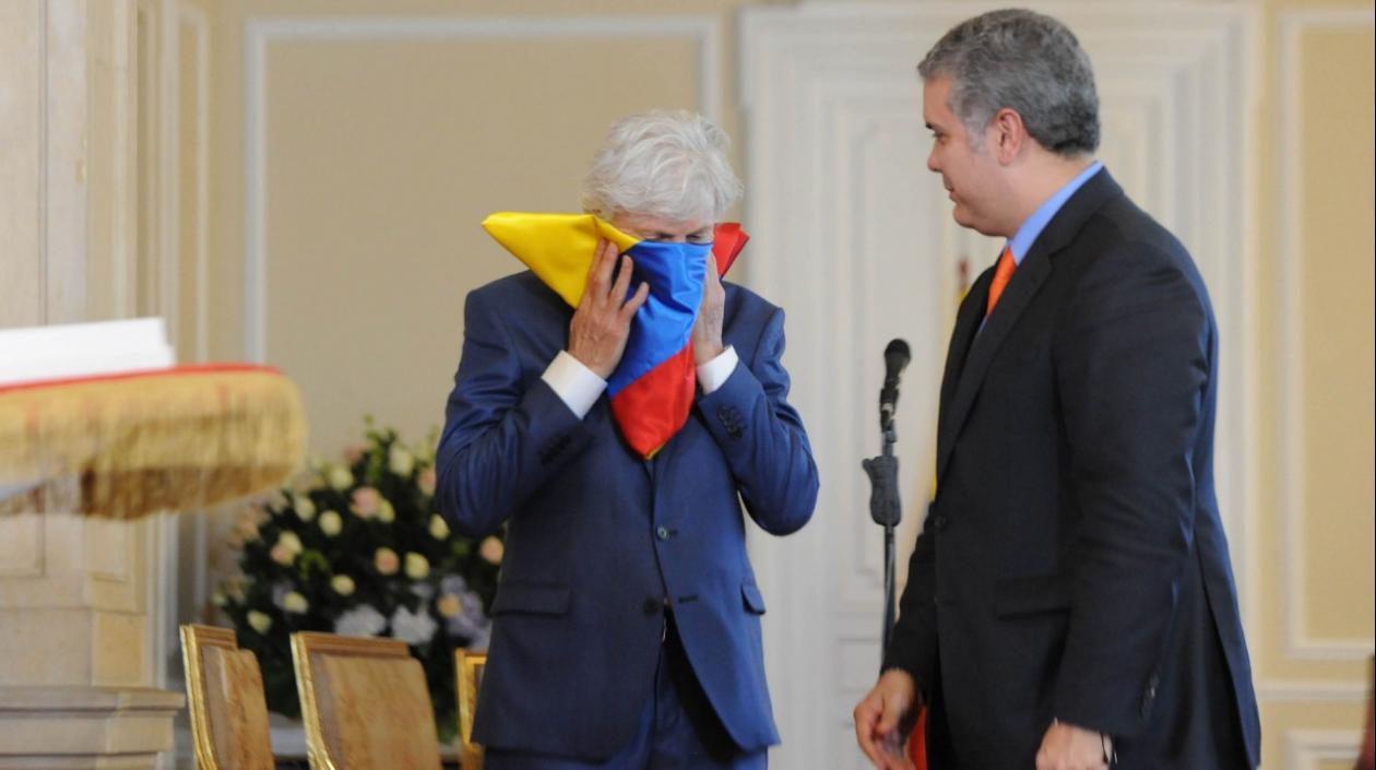 El Presidente Duque rindió homenaje a José Néstor Pékerman, quien besa la bandera, por su labor al frente de la Selección Colombia.