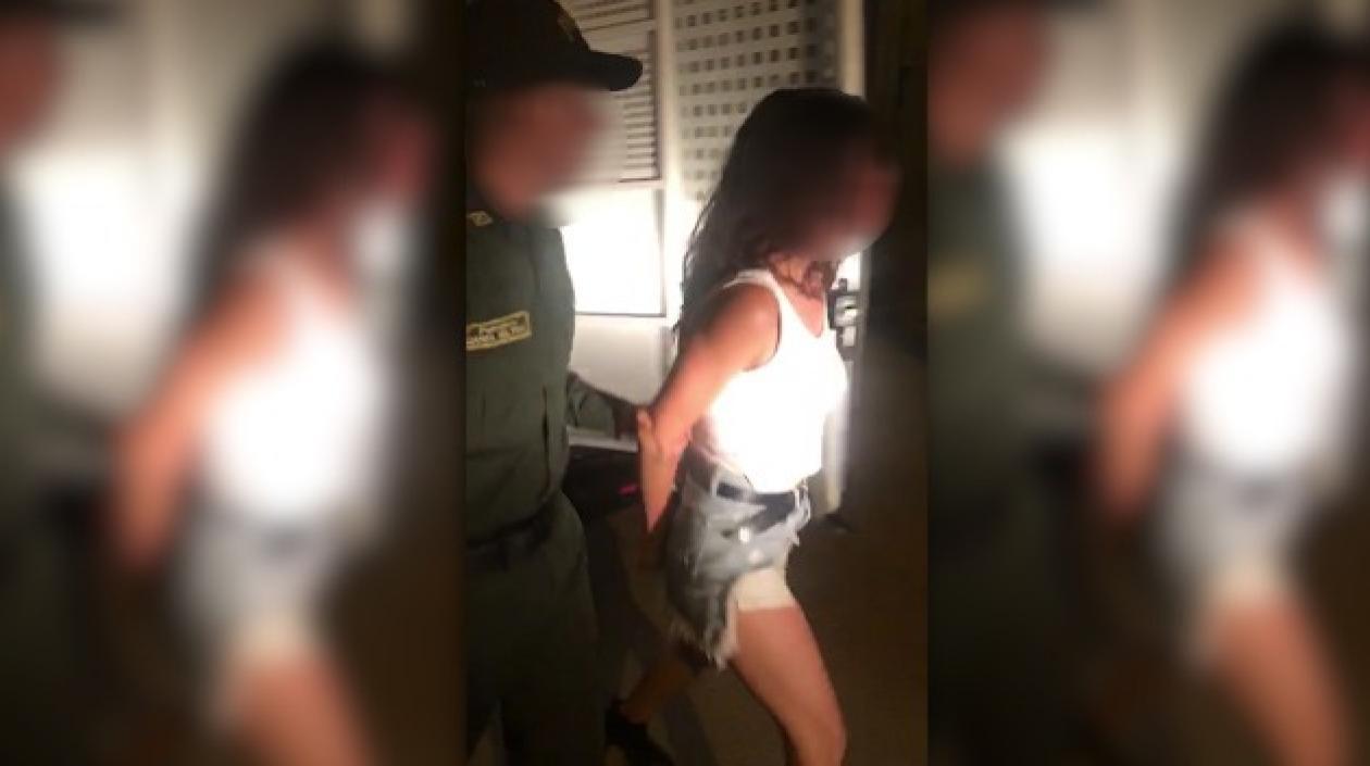 Mujer detenida siendo conducida por los agentes de la Policía. 