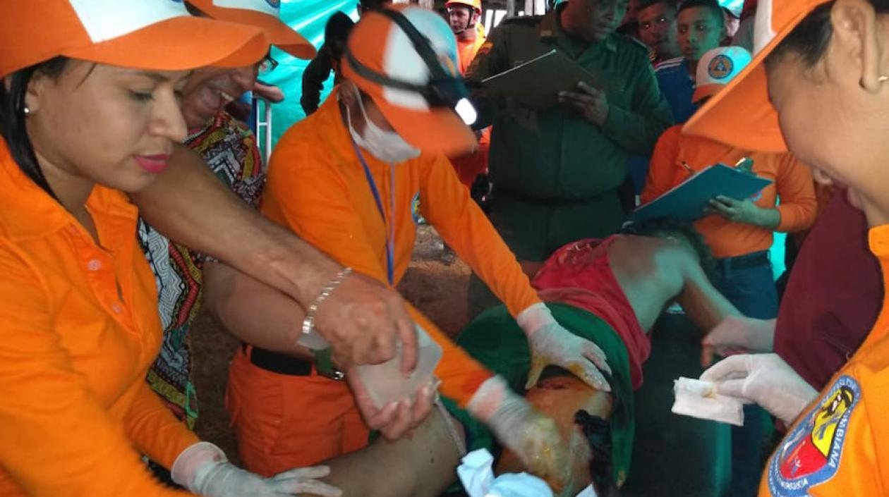 Voluntarios de la Defensa Civil atendiendo a uno de los lesionados.