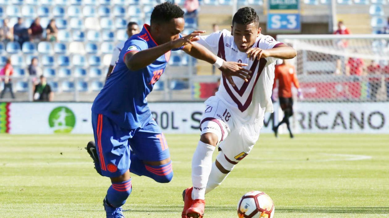 El jugador de Venezuela Brayan Palmezano (d) disputa el balón con Brayan Vera (i) de Colombia.