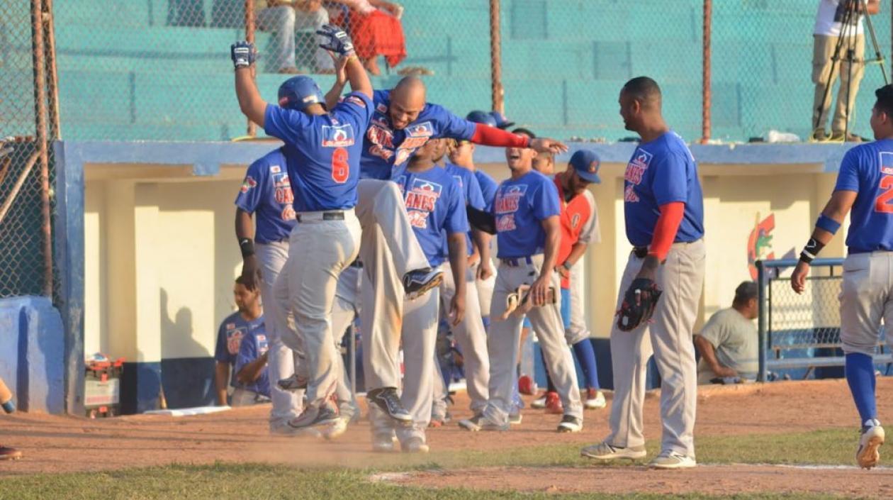 Peloteros de Caimanes celebrando el primer carreraje del partido con cuadrangular de Christian Correa.