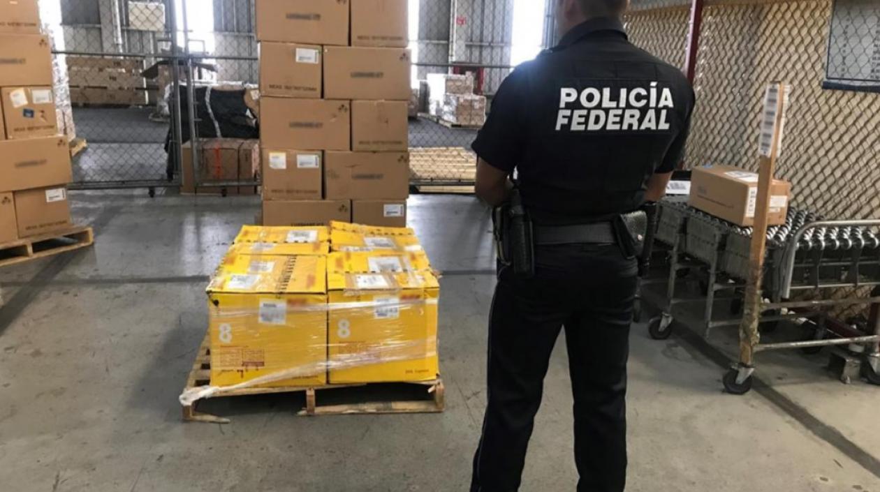 Policías custodian el cargamento de metanfetamina incautado en México.