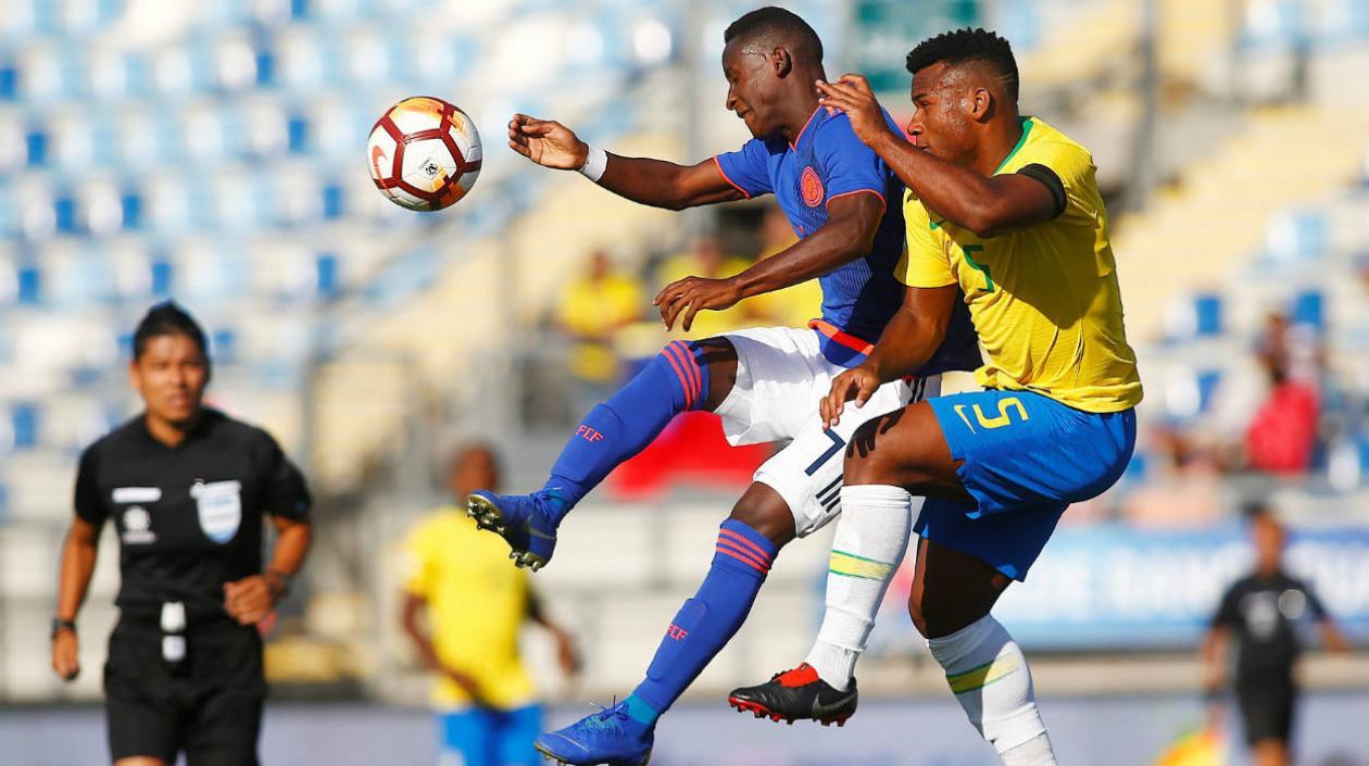 El jugador de la selección brasileña Luan Da Silva (d) disputa el balón con el colombiano Ivan Angulo.