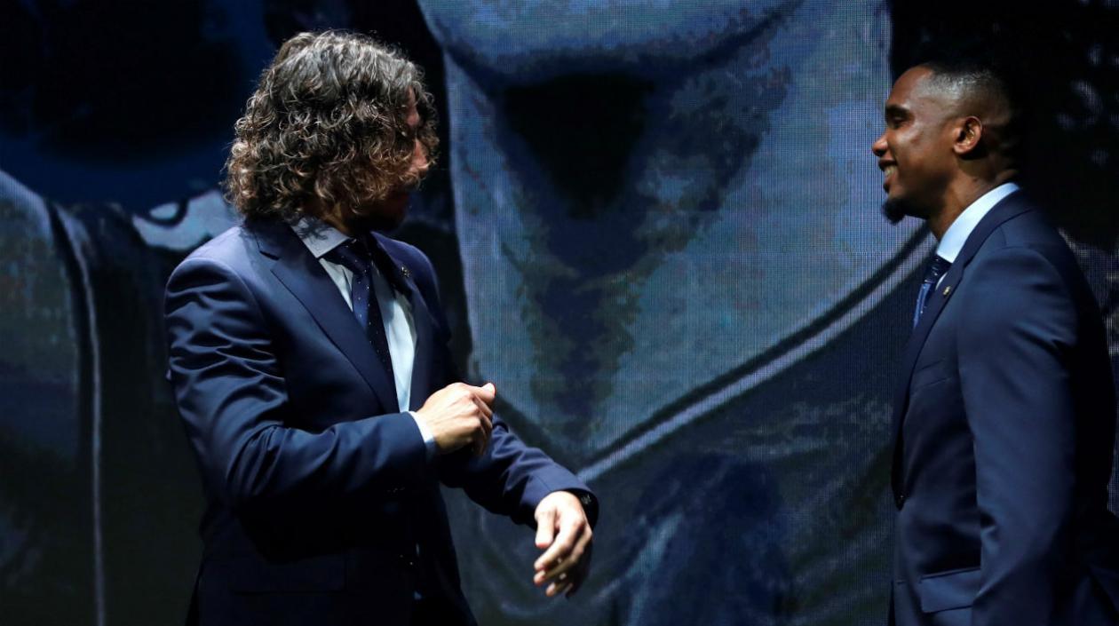 Charles Puyol y Samuel Eto'o dialogan en un evento. 