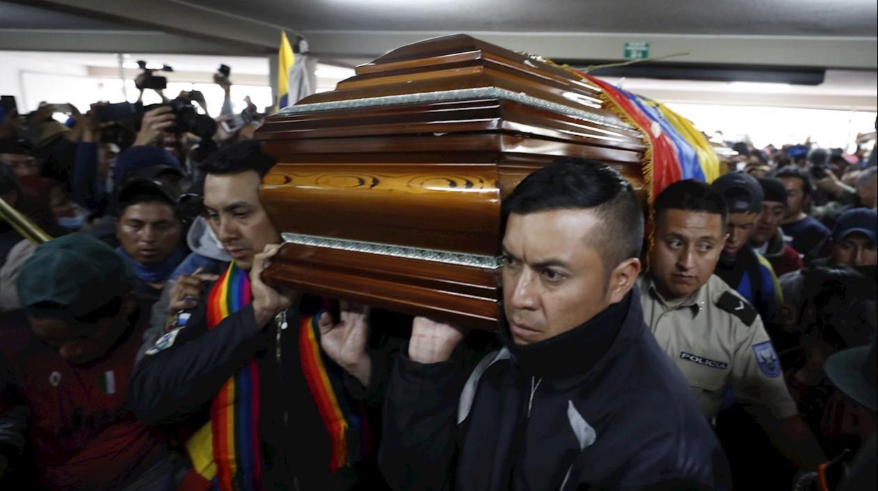 Policías retenidos ayudan a cargar el féretro con el cadáver de un dirigente de la Confederación de Nacionalidades Indígenas (Conaie) que murió ayer durante las protestas