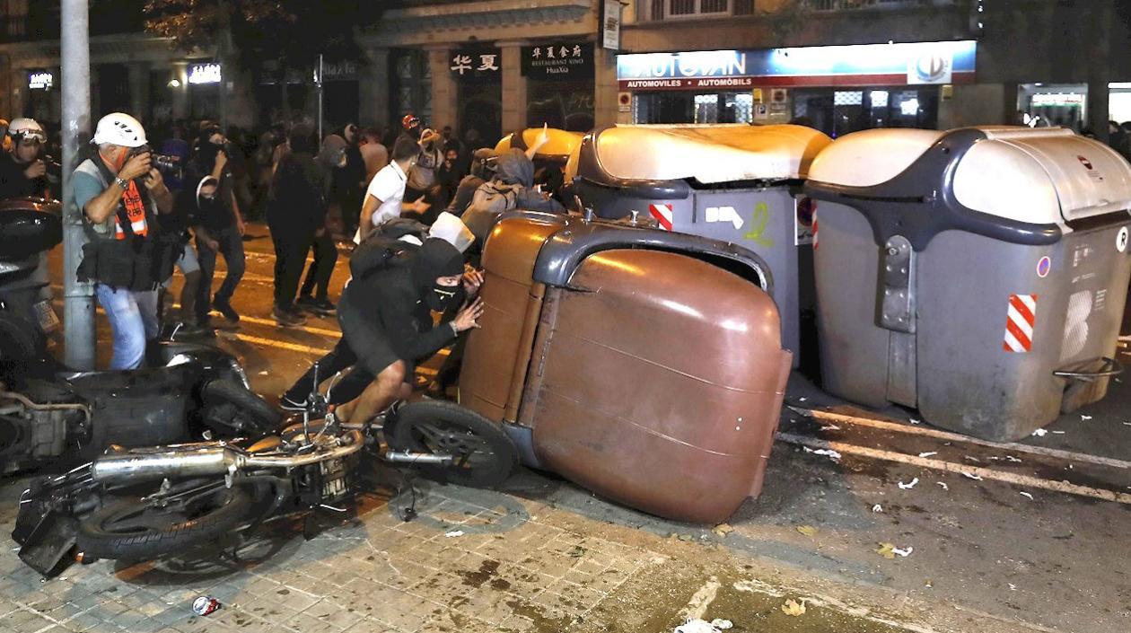 Varios manifestantes vuelcan contenedores en Barcelona.