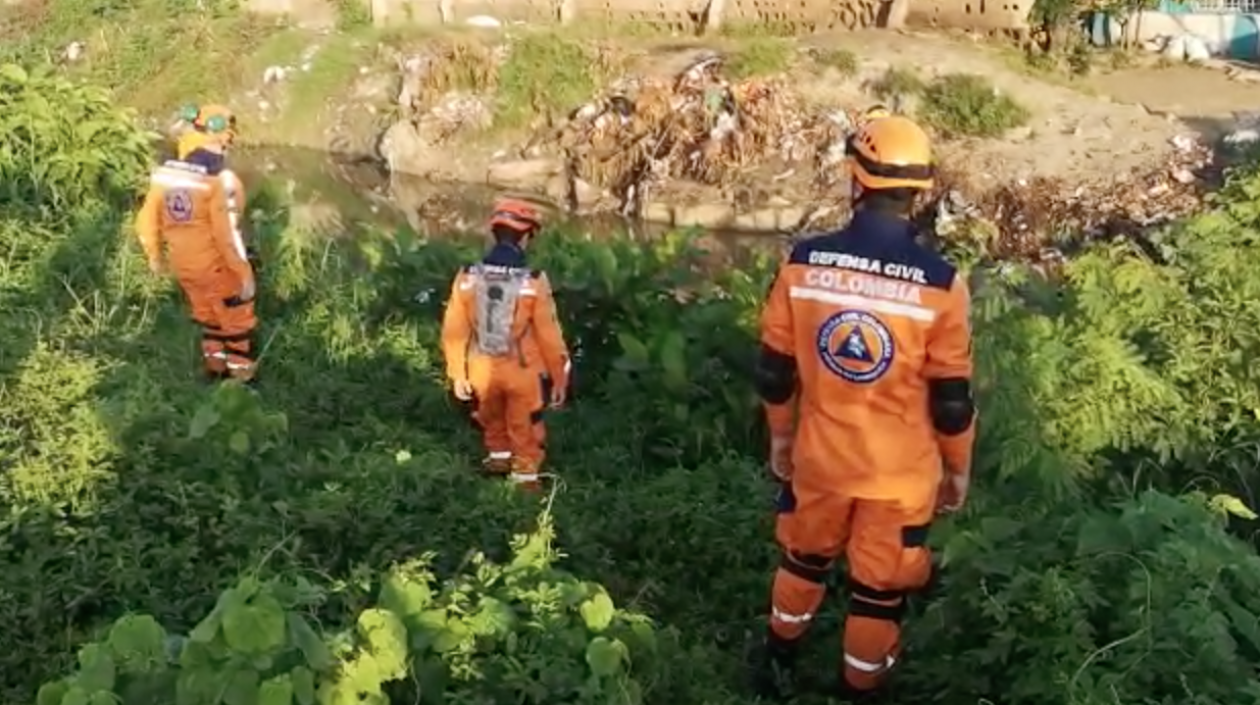 Miembros de la Defensa Civil buscan al menor de edad.