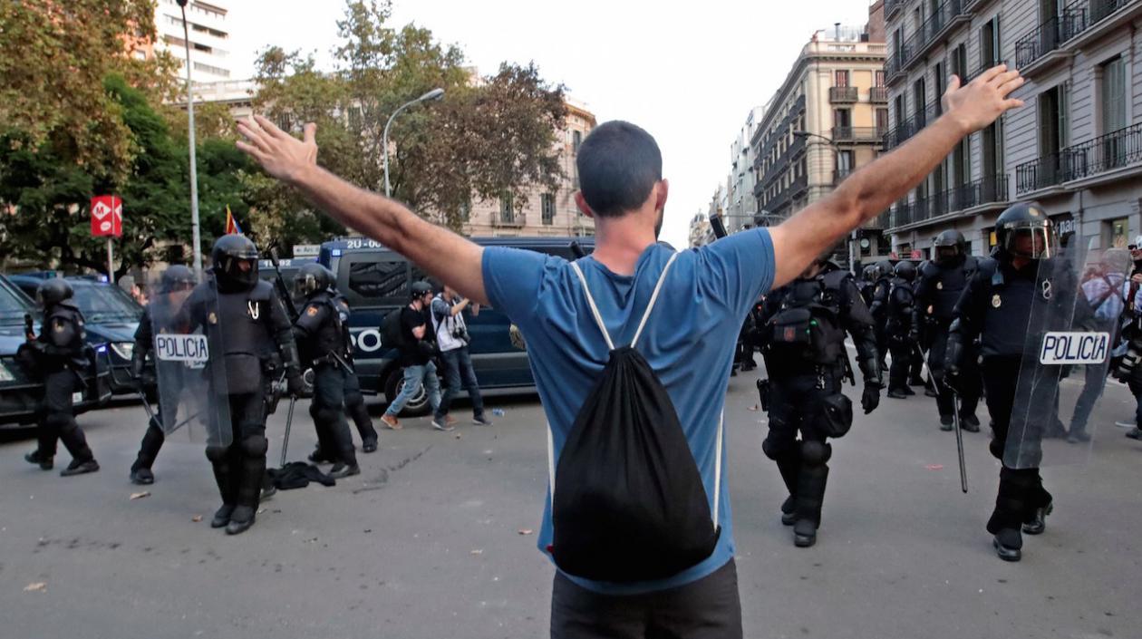 Un hombre se encara con la policía en la plaza de Urquinaona durante una nueva protesta convocada por los autodenominados Comités de Defensa de la República (CDR).