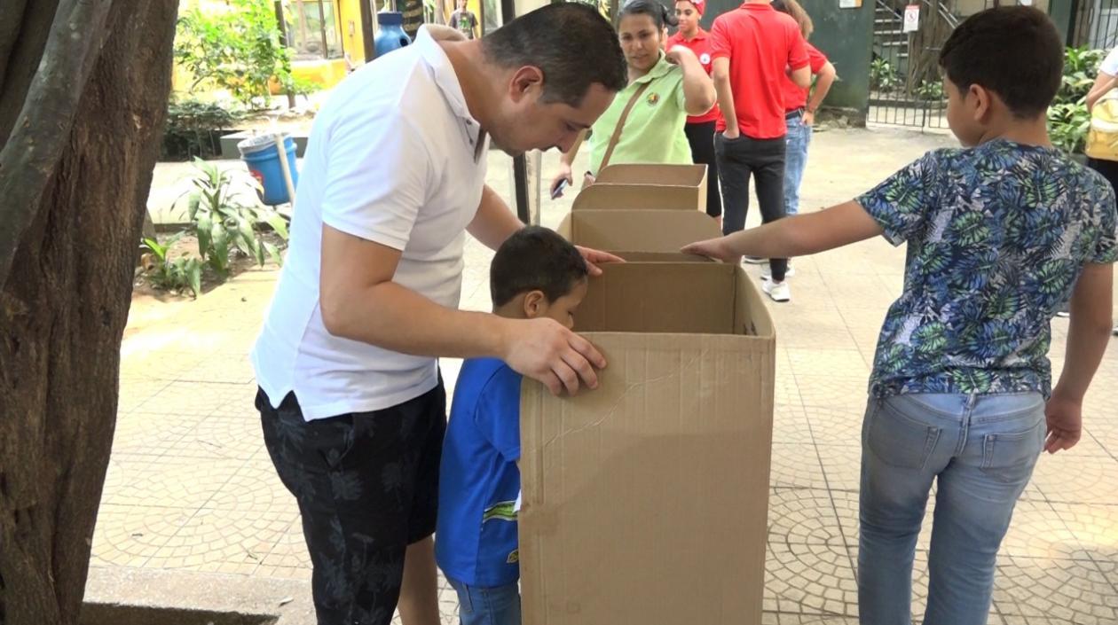 Padre de familia acompañando a su hijo a votar en el Zoo.