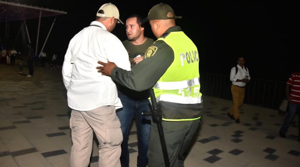 El periodista acorralado por la seguridad presidencial y la Policía.