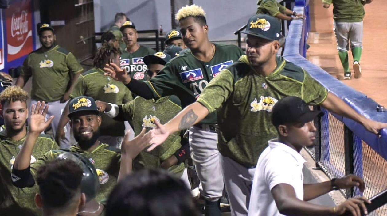 Jugadores de Toros celebran una anotación.